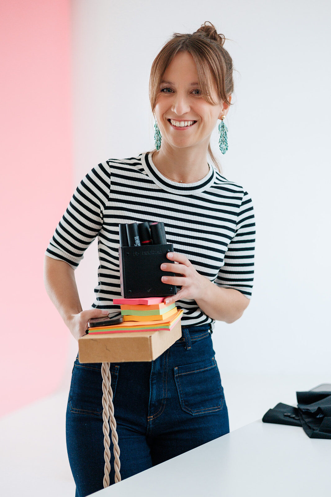 Nicole Forrai lächelt freundlich in die Kamera. Sie hält Material für die Arbeit an der Prozessbegleitung in der Hand.
