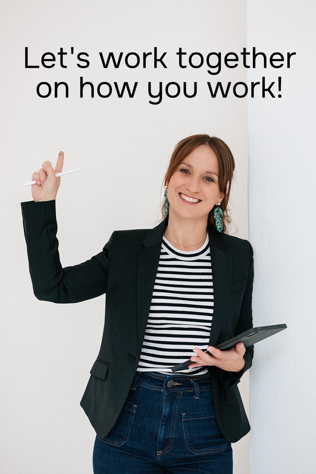 Nicole Forrai steht mit einem Tablet in der Hand vor einer weißen Wand. Über ihr steht der Satz "Let's work together on how you work", der dafür steht, die Zusammenarbeit im Team zu verbessern.